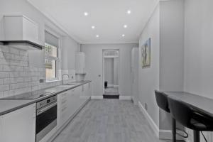 a kitchen with white cabinets and a black counter at Brand New Huge 2 Bedroom Ground Floor Flat in Plymouth