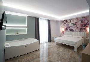 a white bedroom with a bed and a tub at Harmony Tropea Rooms & Suites in Tropea