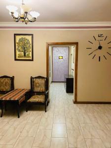 um quarto com um relógio na parede e duas cadeiras em Eco em Yerevan