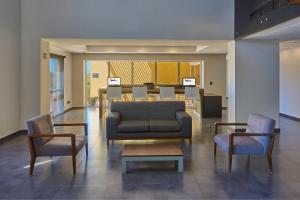 a lobby with a couch and two chairs and a table at City Express by Marriott Cananea in Cananea