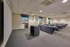 une salle de conférence avec des rangées de tables et de chaises dans l'établissement City Express by Marriott Cananea, à Cananea