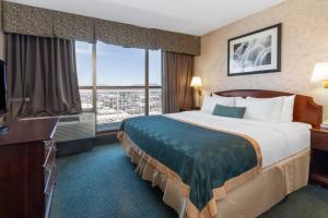 a hotel room with a bed and a large window at Ramada by Wyndham Reno Hotel & Casino in Reno