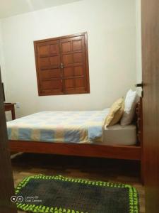 a bedroom with a bed with a window and a door at Casa da Seriema em Lapinha da Serra in Santana do Riacho