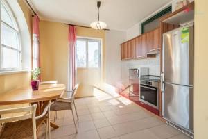 une cuisine avec une table et un réfrigérateur en acier inoxydable dans l'établissement Okouzlující vila u jezera Lhota, à Lhota