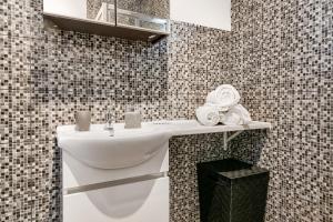 a bathroom with a white sink in a tiled wall at Tavira Balsa Romana - Luz de Tavira in Luz de Tavira +16 photos