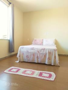 a bedroom with a bed and a rug on the floor at Casa da Seriema em Lapinha da Serra in Santana do Riacho