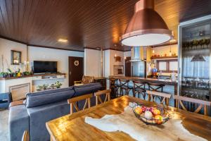 ein Wohnzimmer mit Tisch und Küche in der Unterkunft Alvorada dos Cânions - Altos da Serra in Bom Jardim da Serra