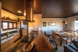 eine Küche mit einem langen Tisch und einem Esszimmer in der Unterkunft Alvorada dos Cânions - Altos da Serra in Bom Jardim da Serra + 18 Fotos