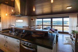 eine Küche mit einem Herd und ein Wohnzimmer in der Unterkunft Alvorada dos Cânions - Altos da Serra in Bom Jardim da Serra