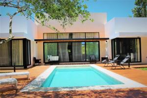 a swimming pool in front of a house at ¡Increible! Villa Luz de Luna in Akumal