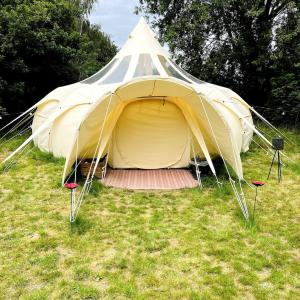 uma grande tenda sentada num campo de relva em Tallulah Belle em Abbots Bromley