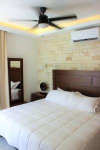 a bedroom with a white bed and a ceiling fan at ¡Increible! Villa Luz de Luna in Akumal +194 photos