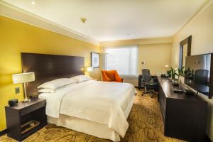 ein Hotelzimmer mit einem Bett und einem TV in der Unterkunft Sheraton Quito in Quito