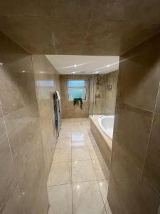 a large bathroom with a tub and a sink at Cosy 3-Bed house in Clydach - TV in every bedroom! in Clydach