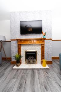 ein Wohnzimmer mit einem Kamin und einem Flachbild-TV in der Unterkunft Greenbourne - 4 bedrooms Sleeps 8 free parking in Gateshead