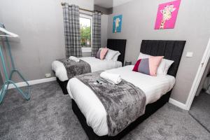 a hotel room with two beds and a window at Greenbourne - 4 bedrooms Sleeps 8 free parking in Gateshead