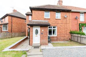 a red brick house with a white door at Greenbourne - 4 bedrooms Sleeps 8 free parking in Gateshead