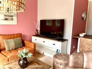 ein Wohnzimmer mit einem Sofa und einem TV in der Unterkunft Ferienwohnung Bootsmann in Langeoog
