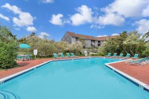 AmagansettUnit 1925 Ocean Colony Beach的一个带椅子的大型游泳池和一栋建筑