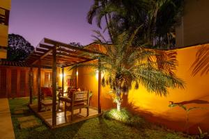 a house with a palm tree in front of it at Pousada Villa Verano in Paraty