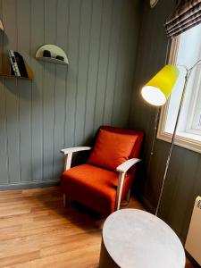 a room with a chair and a lamp and a table at Nes Gard in H&oslash;yheimsvik