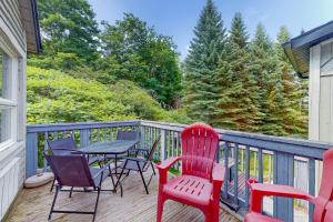una terrazza con sedie rosse e un tavolo sopra di Condo 912 at North Creek Resort a Blue Mountains
