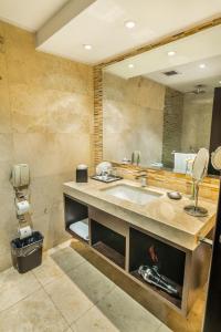La salle de bains est pourvue d'un lavabo et d'un grand miroir. dans l'établissement Sheraton Quito, à Quito