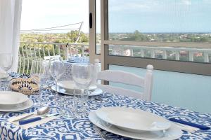 un tavolo con piatti e bicchieri in cima a un balcone di Bellavista Apartment a Santa Maria del Focallo
