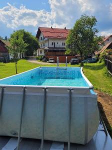 a pool in a yard with a house in the background at Vila Denisa in Bran
