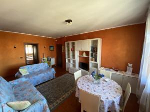 uma sala de estar com uma mesa e um sofá em SANT'ANNA SWEET HOME AI CONFINI DELLE LANGHE em Narzole