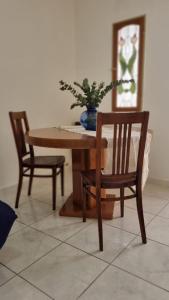 una mesa con dos sillas y un jarrón con una planta en Departamento Aristobulo en La Cieneguita