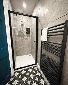 a bathroom with a shower with a tiled floor at 1 West End Boutique Apartment in Bowness-on-Windermere