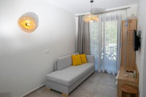 a living room with a couch and a yellow pillow at Arodo Suites in Iraklitsa