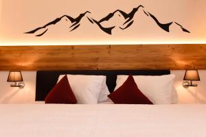 a bedroom with a bed with mountains on the wall at Apartment Marent Garten Chalet in Vandans