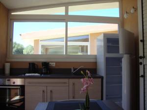 a kitchen with a large window above a sink at Camping Residence Chalet La Pomposa Terrazzoni in Bonifacio