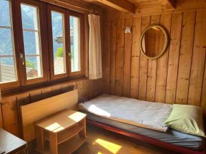 Habitación pequeña con cama y espejo. en Appartamento accogliente di montagna a Cavagnago, en Faido
