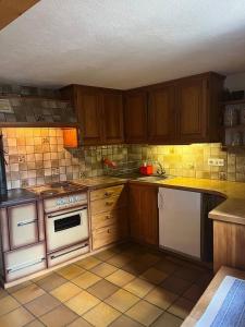 a kitchen with white appliances and wooden cabinets at Appartamento accogliente di montagna a Cavagnago in Faido