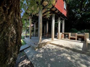 einem Pavillon mit einem Tisch und Bänken unter einem Baum in der Unterkunft Kuca i splav na reci Savi in Belgrad