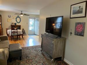 a living room with a flat screen tv on a dresser at Sunny 2 BR Apartment west of Chicago in quaint Forest Park center in Forest Park