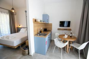 a hotel room with a bed and a sink and a table at Arodo Suites in Iraklitsa