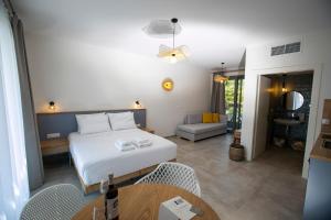a bedroom with a bed and a table and chairs at Arodo Suites in Iraklitsa +128 photos