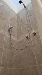 a shower with a shower head in a bathroom at Departamento Aristobulo in La Cieneguita +16 photos