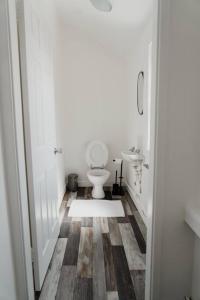 a white bathroom with a toilet and a sink at Bentley Lofts - By Sigma Stays in Crewe