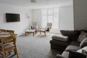 a living room with a couch and a table and chairs at Bentley Lofts - By Sigma Stays in Crewe