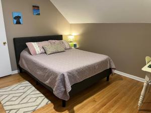 um quarto com uma cama com uma cabeceira preta em Sunny 2 BR Apartment west of Chicago in quaint Forest Park center em Forest Park