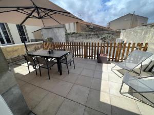 eine Terrasse mit Tisch und Stühlen und einem Sonnenschirm in der Unterkunft Appartement centre ville * terrasse * clim * WIFI * Haut de gamme * in Angoulême