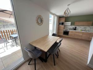 eine Küche und ein Esszimmer mit einem Holztisch und Stühlen in der Unterkunft Appartement centre ville * terrasse * clim * WIFI * Haut de gamme * in Angoulême