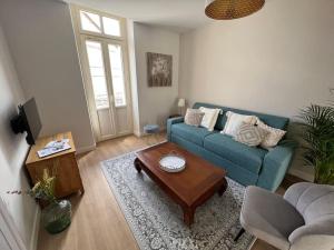 een woonkamer met een blauwe bank en een salontafel bij Appartement centre ville * terrasse * clim * WIFI * Haut de gamme * in Angoulême
