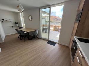ein Esszimmer mit einem Tisch und einem Balkon in der Unterkunft Appartement centre ville * terrasse * clim * WIFI * Haut de gamme * in Angoulême + 11 Fotos