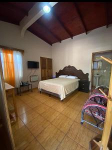 1 dormitorio con 1 cama y suelo de madera en Hotel y Balneario Villa Paraíso, en Catacamas
